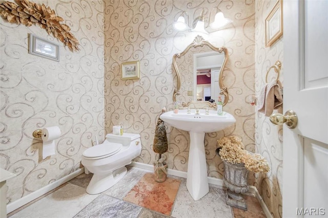 half bath featuring wallpapered walls, baseboards, and toilet