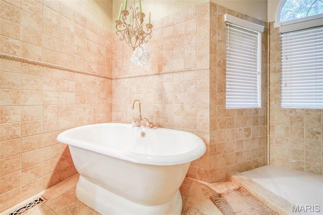 full bath with tile walls, a soaking tub, and tile patterned flooring
