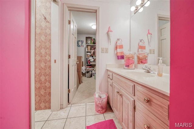 bathroom featuring vanity, tile patterned flooring, and a walk in closet