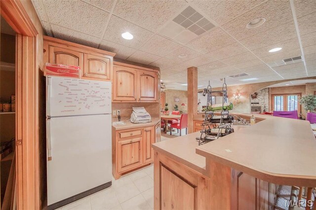 kitchen with freestanding refrigerator, light countertops, a paneled ceiling, recessed lighting, and light tile patterned flooring