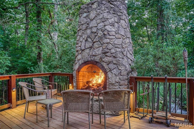 wooden terrace with an outdoor stone fireplace
