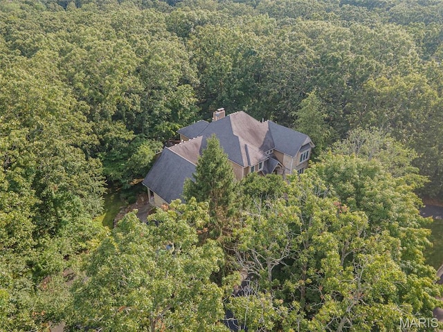 aerial view of property and surrounding area with a heavily wooded area
