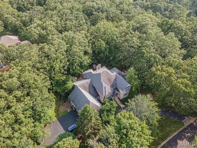 aerial view of property and surrounding area with a heavily wooded area
