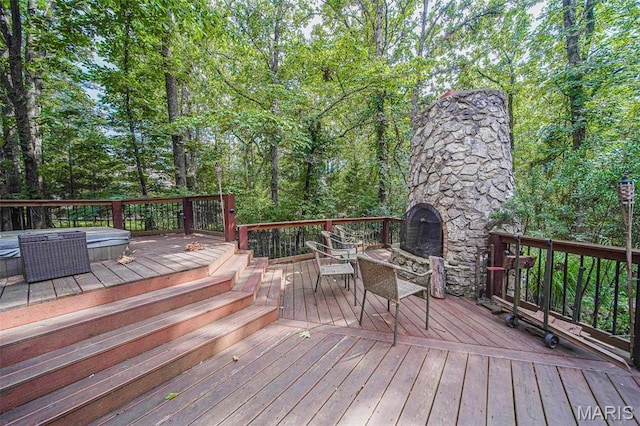 deck with an outdoor stone fireplace and outdoor dining space