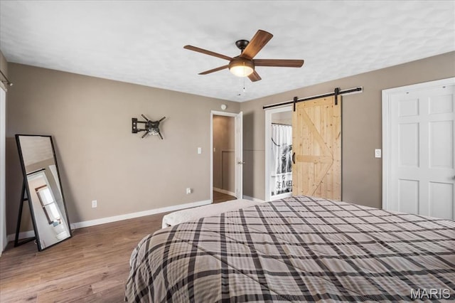 6639 Gladel Dr, Waterloo, IL 62298 - bedroom with a barn door, wood finished floors, and ceiling fan