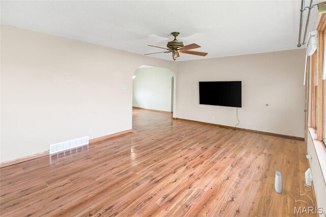 1219 N Park St, Hardin, IL 62047 - unfurnished living room with arched walkways, a ceiling fan, light wood finished floors, and baseboards