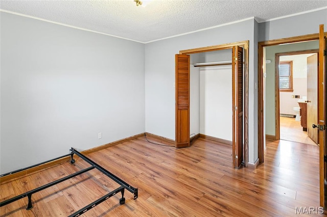 1219 N Park St, Hardin, IL 62047 - unfurnished bedroom featuring a closet, light wood-style flooring, a textured ceiling, baseboards, and crown molding