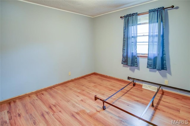 1219 N Park St, Hardin, IL 62047 - spare room with wood finished floors, a textured ceiling, baseboards, and crown molding
