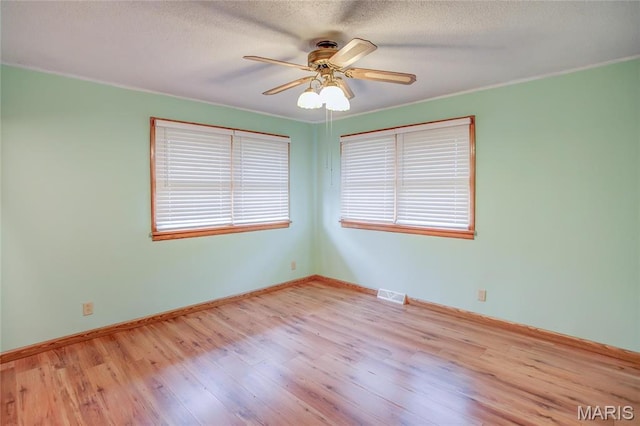 1219 N Park St, Hardin, IL 62047 - empty room featuring wood finished floors, a ceiling fan, healthy amount of natural light, baseboards, and a textured ceiling