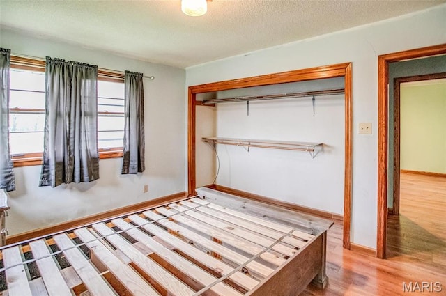 1219 N Park St, Hardin, IL 62047 - unfurnished bedroom with wood finished floors, a closet, a textured ceiling, and baseboards