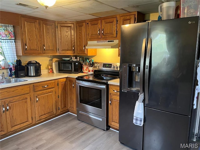 101 County Road 5170, Salem, MO 65560 - kitchen featuring fridge with ice dispenser, stainless steel electric range, under cabinet range hood, brown cabinets, and a paneled ceiling