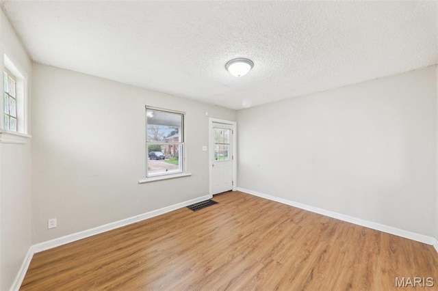 241 Dammert Ave, Saint Louis, MO 63125 - unfurnished room with wood finished floors, baseboards, and a textured ceiling