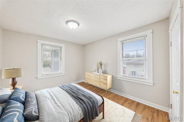241 Dammert Ave, Saint Louis, MO 63125 - bedroom featuring multiple windows, wood finished floors, baseboards, and a textured ceiling