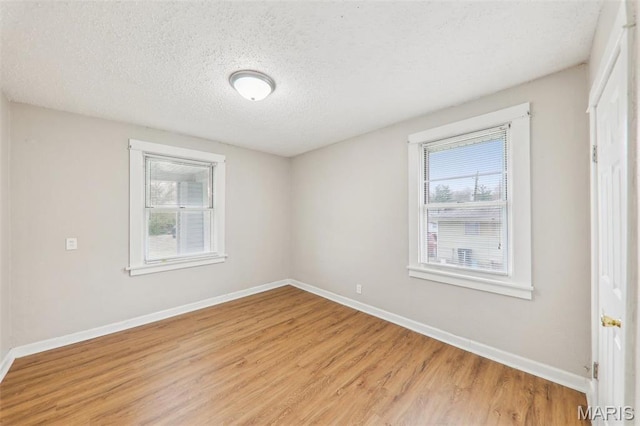 241 Dammert Ave, Saint Louis, MO 63125 - spare room featuring light wood-style floors, plenty of natural light, a textured ceiling, and baseboards
