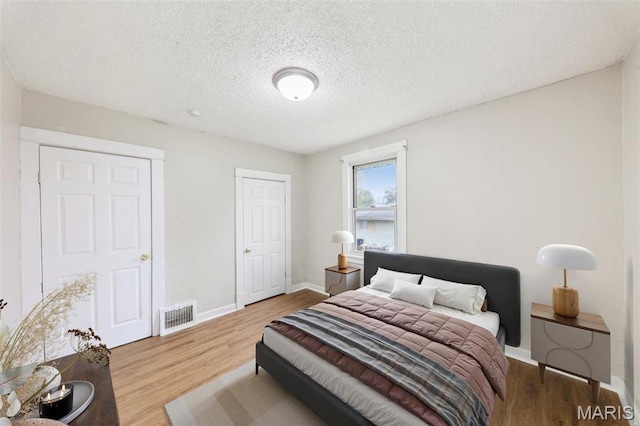 241 Dammert Ave, Saint Louis, MO 63125 - bedroom with wood finished floors, baseboards, and a textured ceiling