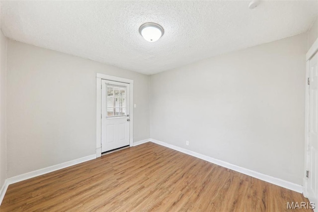 241 Dammert Ave, Saint Louis, MO 63125 - spare room featuring light wood-style floors, a textured ceiling, and baseboards