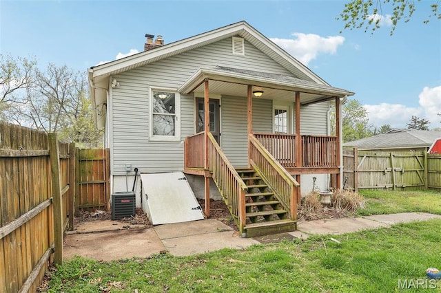 241 Dammert Ave, Saint Louis, MO 63125 - view of front facade with a porch, central air condition unit, a fenced backyard, and a chimney