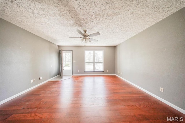 unfurnished room featuring ceiling fan, wood finished floors, baseboards, and a textured ceiling