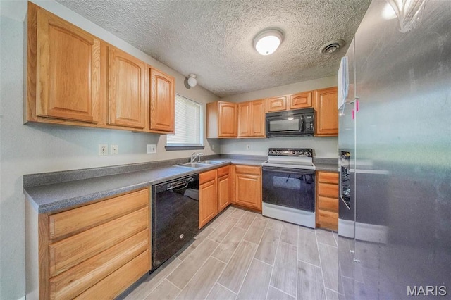 kitchen featuring black appliances, a sink, a textured ceiling, and wood tiled floors