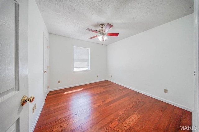 unfurnished room with ceiling fan, a textured ceiling, wood finished floors, and baseboards