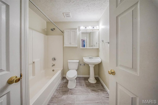 bathroom with toilet, shower / bath combination, a textured ceiling, and baseboards