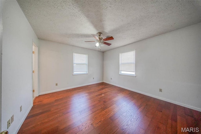spare room with a ceiling fan, wood finished floors, a textured ceiling, and baseboards