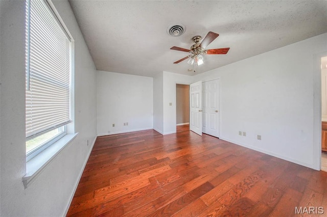 unfurnished bedroom featuring wood finished floors, baseboards, a textured ceiling, and ceiling fan
