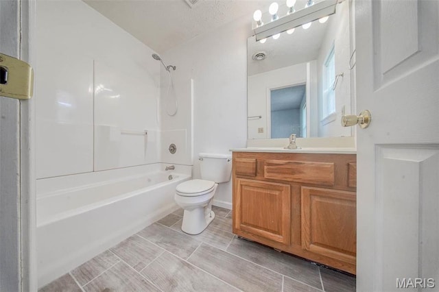 bathroom featuring toilet, vanity, and tub / shower combination