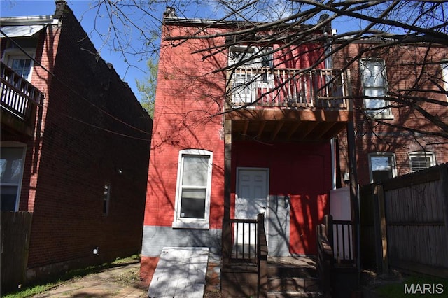 2912 Indiana Ave, Saint Louis, MO 63118 - rear view of house with a balcony, fence, and brick siding