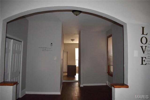 2912 Indiana Ave, Saint Louis, MO 63118 - corridor with arched walkways, baseboards, and dark wood finished floors