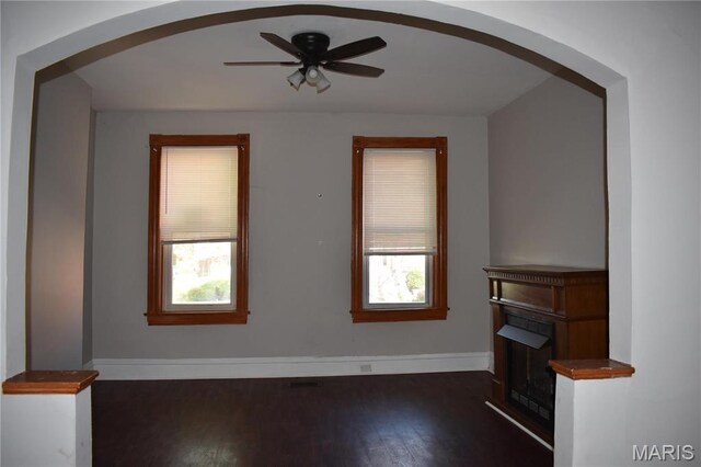 2912 Indiana Ave, Saint Louis, MO 63118 - unfurnished living room featuring arched walkways, plenty of natural light, and wood finished floors