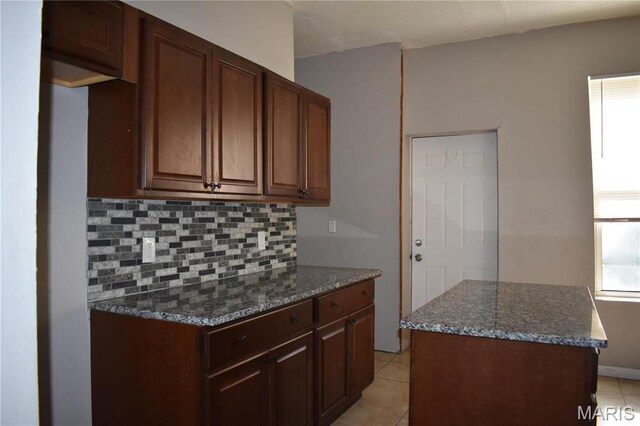 2912 Indiana Ave, Saint Louis, MO 63118 - kitchen with tasteful backsplash, light tile patterned floors, and dark stone counters