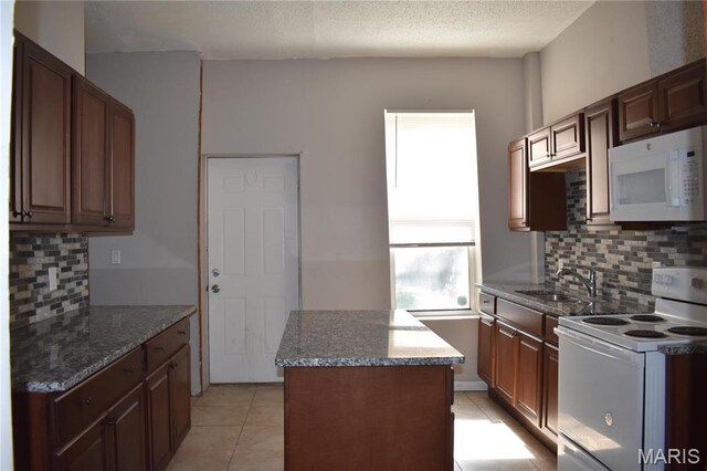 2912 Indiana Ave, Saint Louis, MO 63118 - kitchen with white appliances, a sink, a center island, decorative backsplash, and a textured ceiling