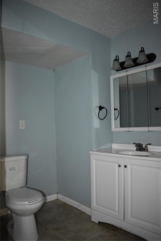2912 Indiana Ave, Saint Louis, MO 63118 - bathroom featuring toilet, vanity, a textured ceiling, baseboards, and tile patterned floors