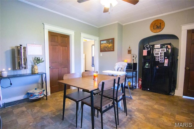 dining area with crown molding, ceiling fan, and arched walkways
