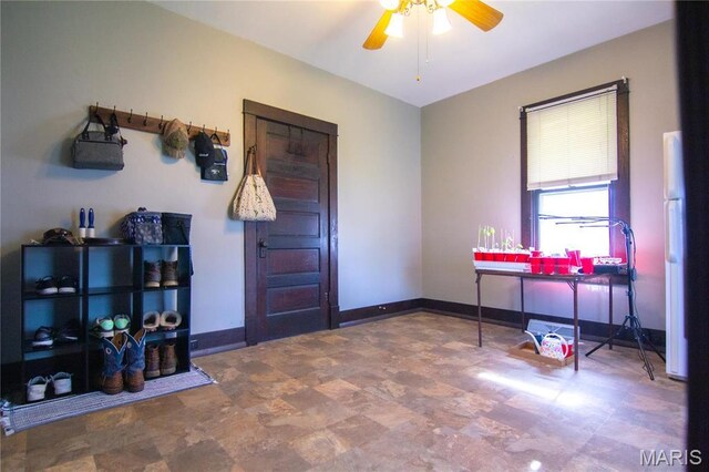office space with ceiling fan and baseboards