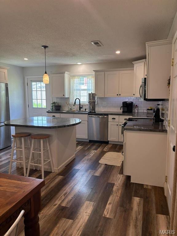 10817 Cabin Ln, Dexter, MO 63841 - kitchen with appliances with stainless steel finishes, dark countertops, a sink, plenty of natural light, and recessed lighting
