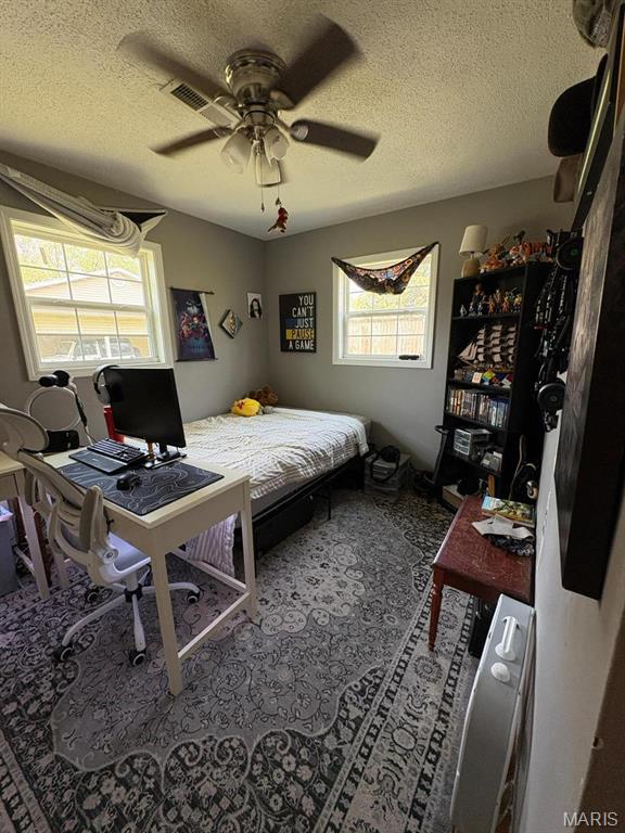 10817 Cabin Ln, Dexter, MO 63841 - bedroom with a textured ceiling, ceiling fan, and a desk
