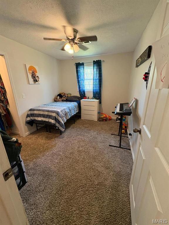 10817 Cabin Ln, Dexter, MO 63841 - bedroom with carpet, a textured ceiling, ceiling fan, and baseboards