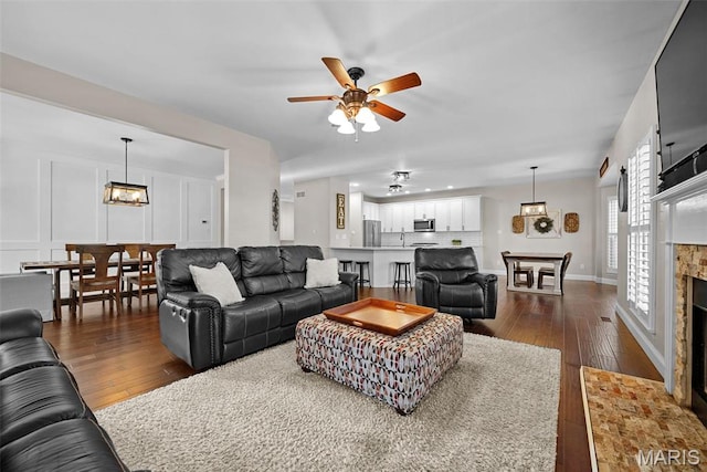 515 Country Chase Dr, Lake St Louis, MO 63367 - living room featuring dark wood-style flooring, a ceiling fan, a fireplace with flush hearth, and baseboards