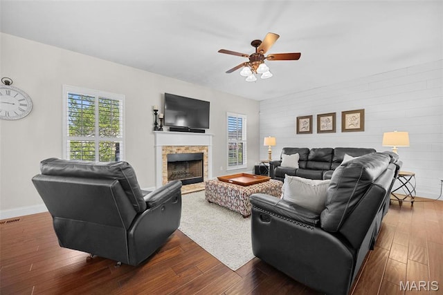 515 Country Chase Dr, Lake St Louis, MO 63367 - living room with healthy amount of natural light, a stone fireplace, a ceiling fan, dark wood-style floors, and wood walls