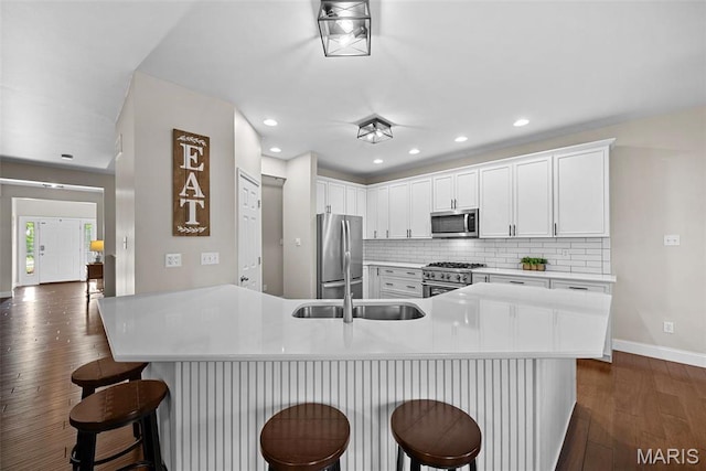 515 Country Chase Dr, Lake St Louis, MO 63367 - kitchen with stainless steel appliances, dark wood-type flooring, baseboards, tasteful backsplash, and a kitchen breakfast bar