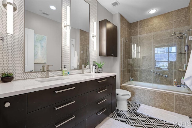 8025 Maryland Ave Unit 2H, Saint Louis, MO 63105 - bathroom featuring tiled shower / bath combo, double vanity, and toilet