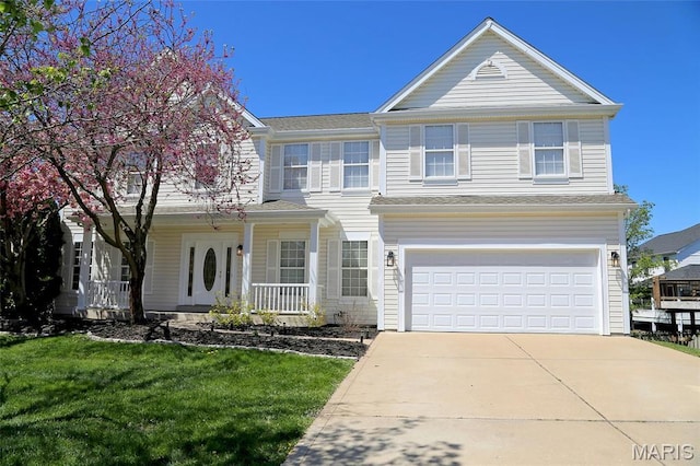 view of front facade with a garage, concrete driveway, covered porch, and a front yard