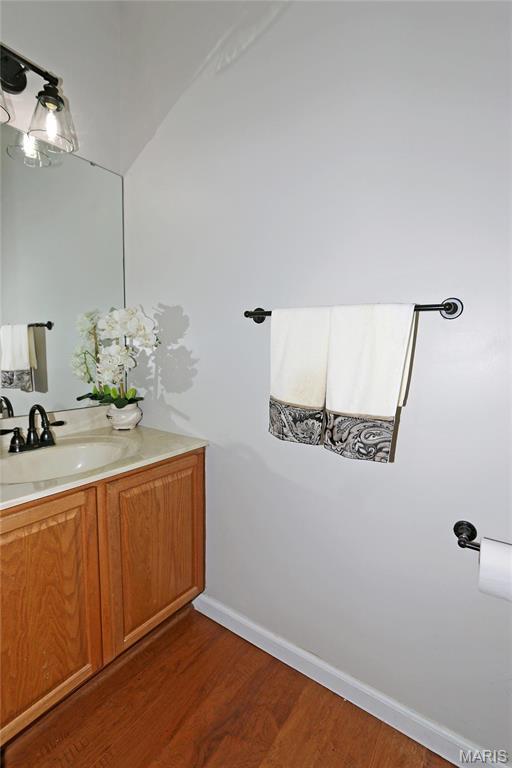 bathroom with wood finished floors, vanity, and baseboards