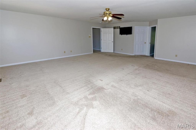carpeted spare room with ceiling fan and baseboards