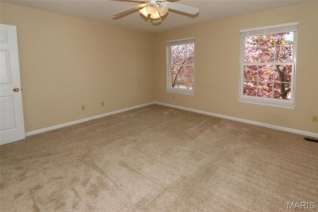 empty room featuring a ceiling fan, carpet floors, and baseboards