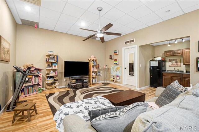 1909 Shepard Rd, Wildwood, MO 63038 - living room featuring light wood-style flooring, ceiling fan, baseboards, and a drop ceiling