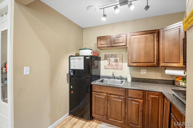 1909 Shepard Rd, Wildwood, MO 63038 - kitchen featuring freestanding refrigerator, a sink, light wood finished floors, brown cabinetry, and dark countertops