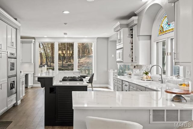 1909 Shepard Rd, Wildwood, MO 63038 - kitchen featuring a sink, a kitchen island, light stone countertops, stainless steel appliances, and a breakfast bar